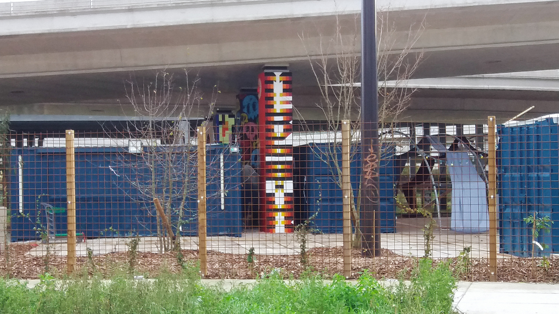 pilier autoroute peint au milieu de containers