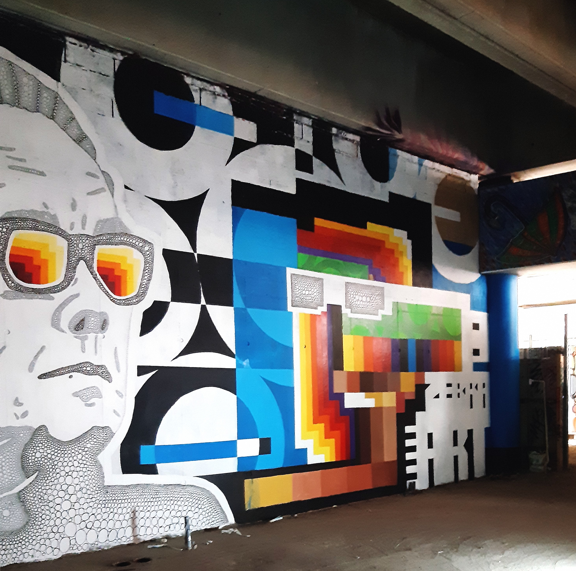 peinture murale collaboration deux artistes noir et blanc et carrés de couleurs jaune orange et bleus