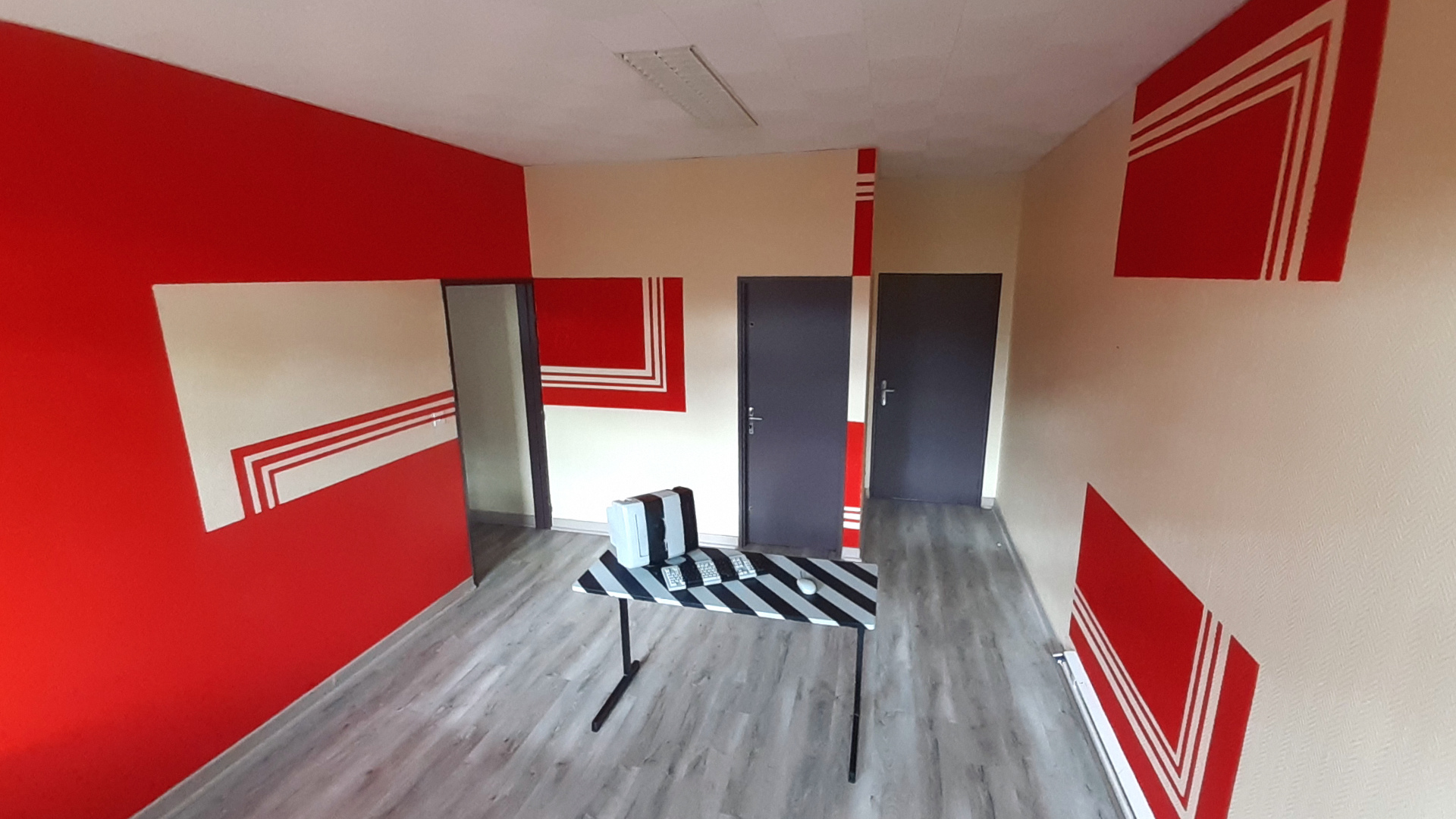 table et murs peints motif géométrique noir rouge