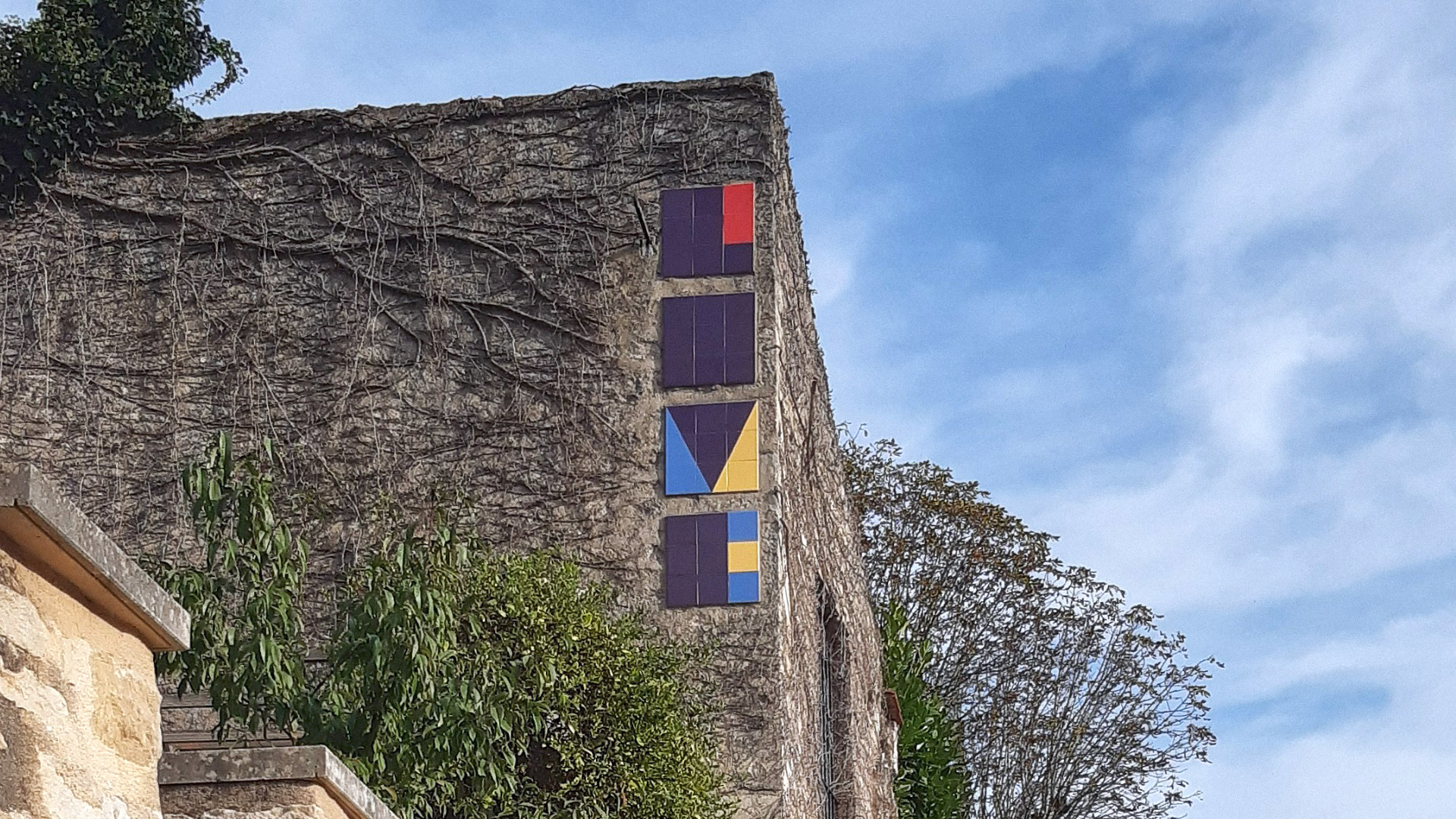 typographie colorisée en céramique collée sur un mur extérieur