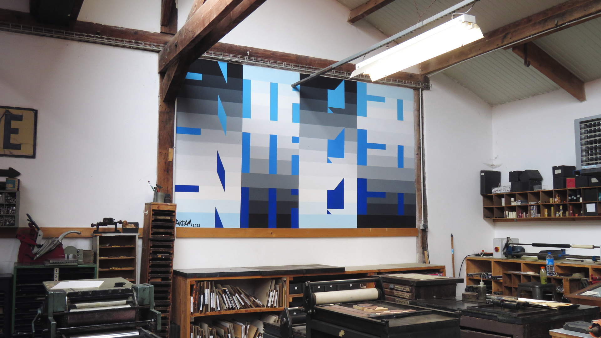 mur intérieur peint lignes dégradées du gris au noir et des touches de bleu