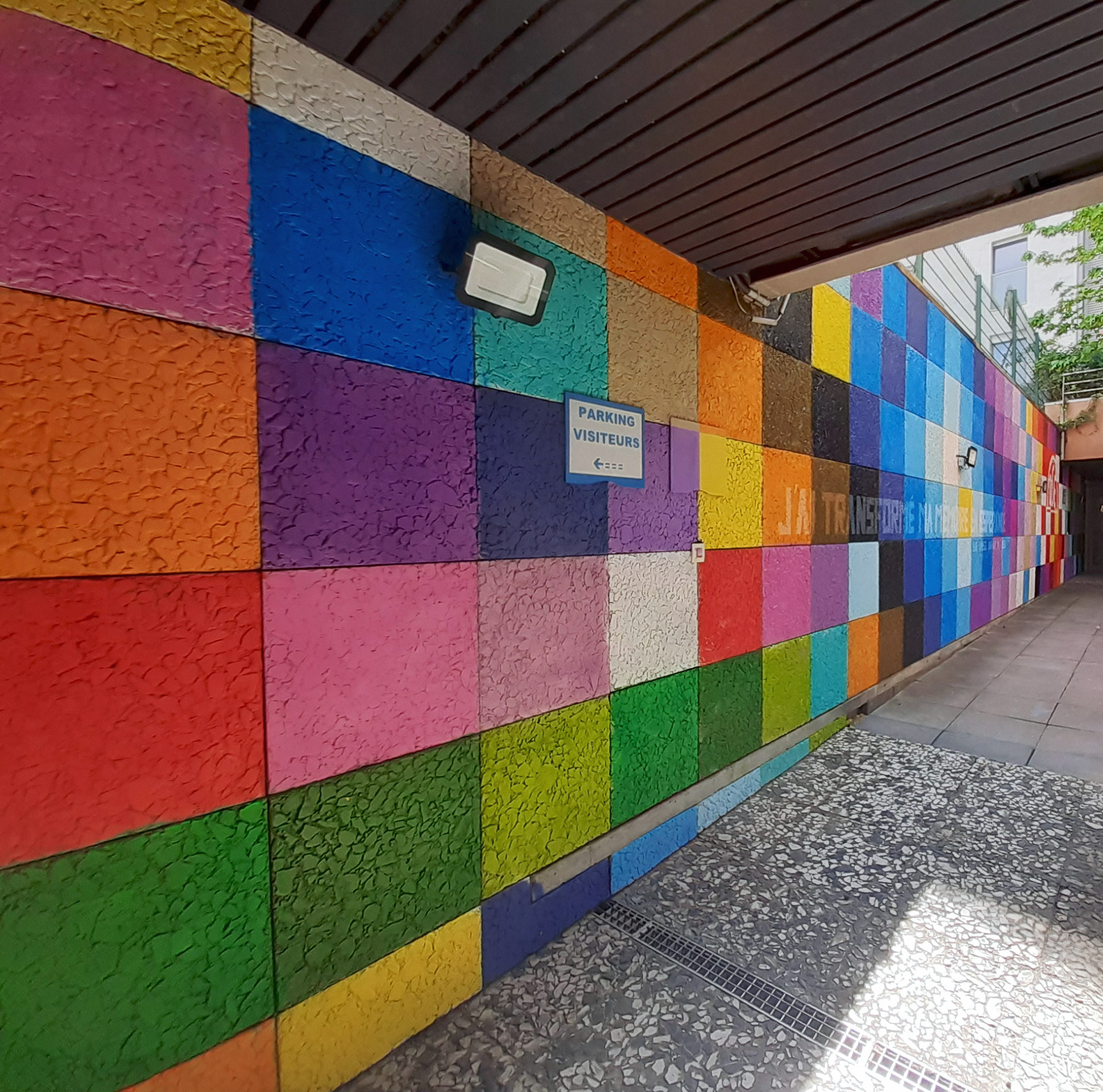 un mur de dalles peint de carrés de couleurs